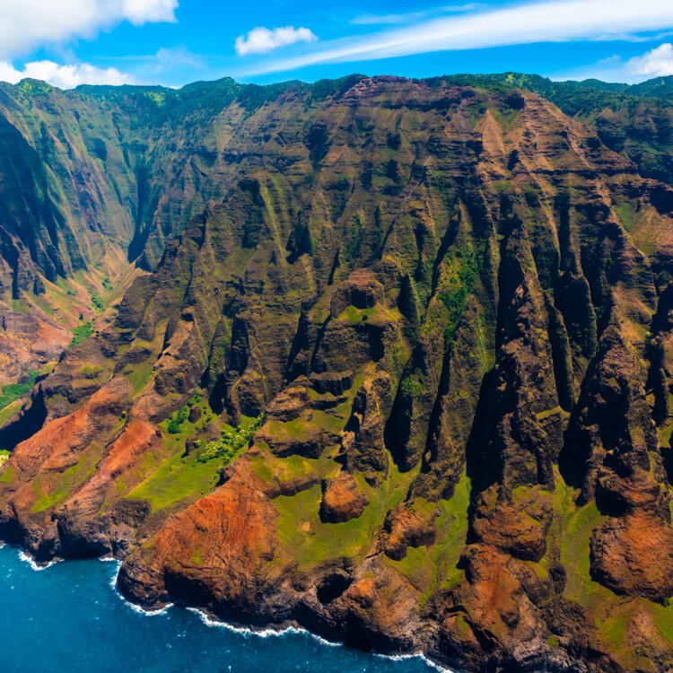 Spektakuläre Luftaufnahme der dramatischen und felsigen Napali-Küste auf Kauai, Hawaiʻi, mit tiefen grünen Tälern und steilen Klippen