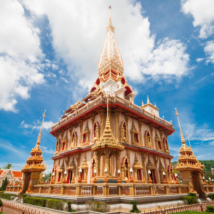 The Wat Chalong temple in Phuket, an impressive multi-storey structure with red and gold roofs, ornate gables and rich decorations