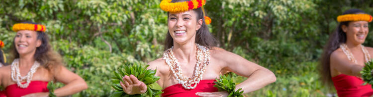 Hawaiianische Tänzerinnen in traditionellen roten Kostümen mit Lei und Hula-Röcken