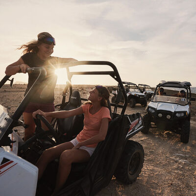 Friends an off-road buggy during a desert adventure tour,