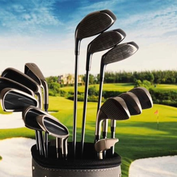  A set of golf clubs in a bag with a lush golf course in the background,