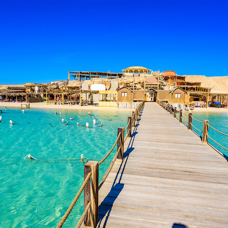 Holzpier am Orange Bay Beach mit kristallklarem azurblauem Wasser und weißem Strand - paradiesische Küste der Insel Giftun, Mahmya, Hurghada, Rotes Meer, Ägypten