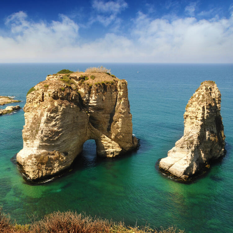 Natürliche Kalksteinformationen Pigeon Rocks vor der Küste von Beirut unter blauem Himmel und klarem Wasser.