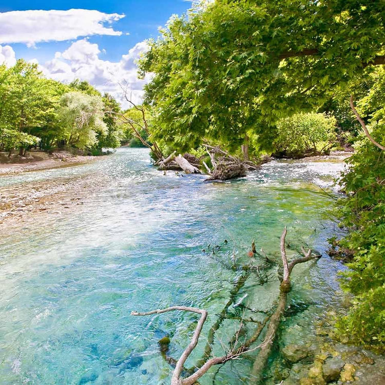 Landschaft und kristallklares Wasser auf dem legendären Fluss Acheron eingerahmt in weißen Steinen, Griechenland