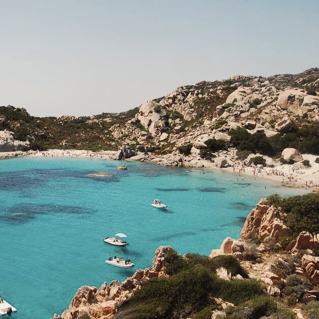 Bucht in Olbia mit Meer im Hintergrund und Gestein im Vordergrund