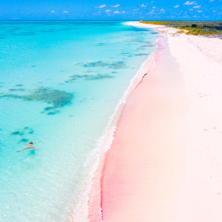 Der Pink Sand Strand auf den Bahamas mit türkisblauem Wasser und rosanen Sand.