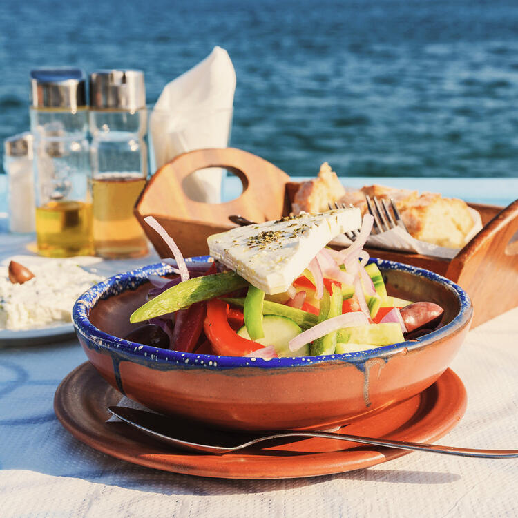 Griechische Köstlichkeiten Griechischer Salat auf einem gedeckten Tisch