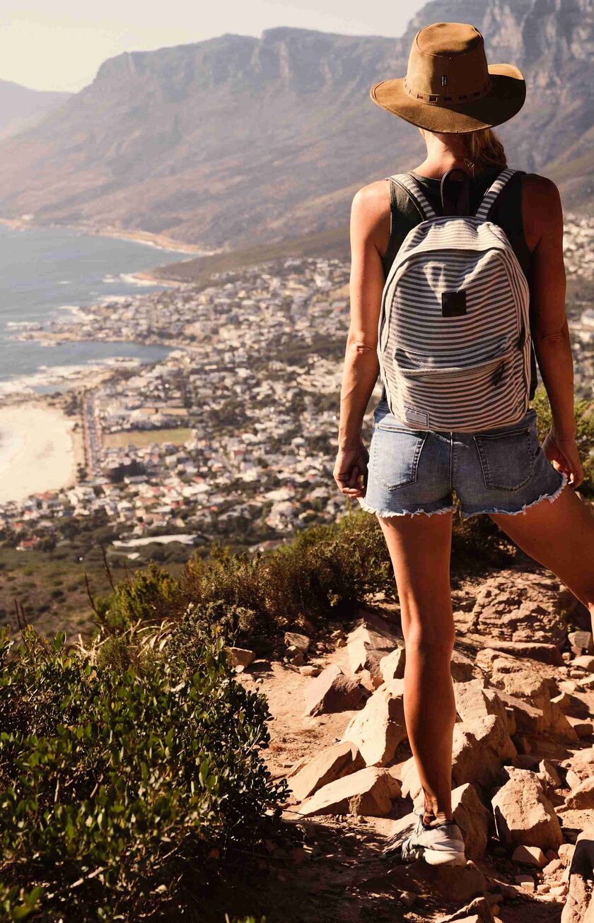 Wanderin mit Blick auf die Küste und eine Stadt in Südafrika