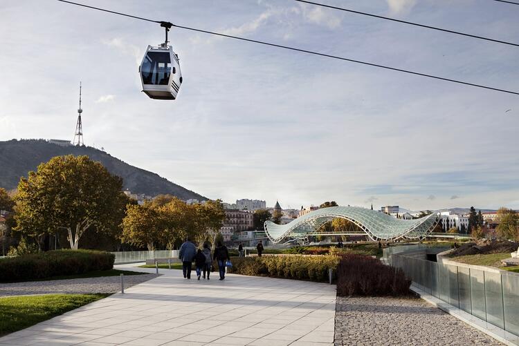 Kabine der Stadtseilbahn schwebt über Passanten