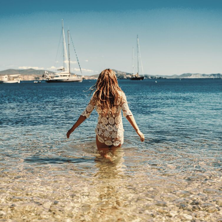 eine Frau geht in das Meer