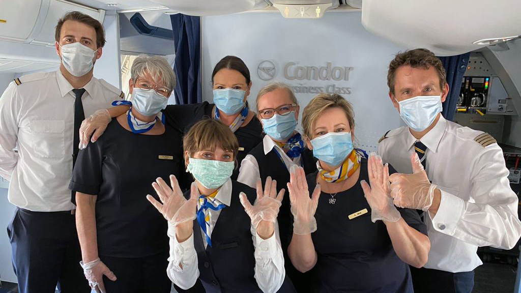 Condor Crew mit Mundschutz in Flugzeugkabine