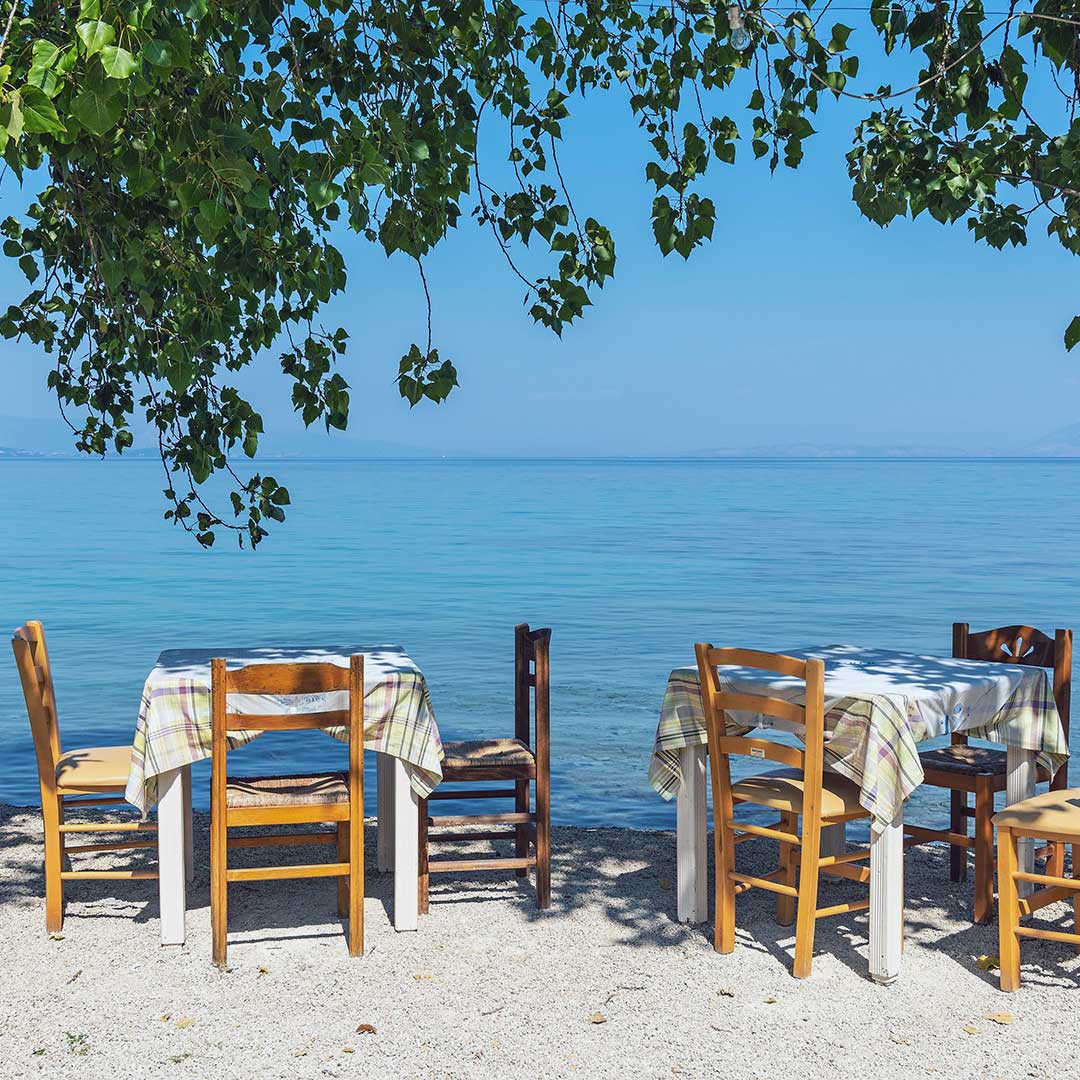 Tische und Stühle an Küste auf Korfu