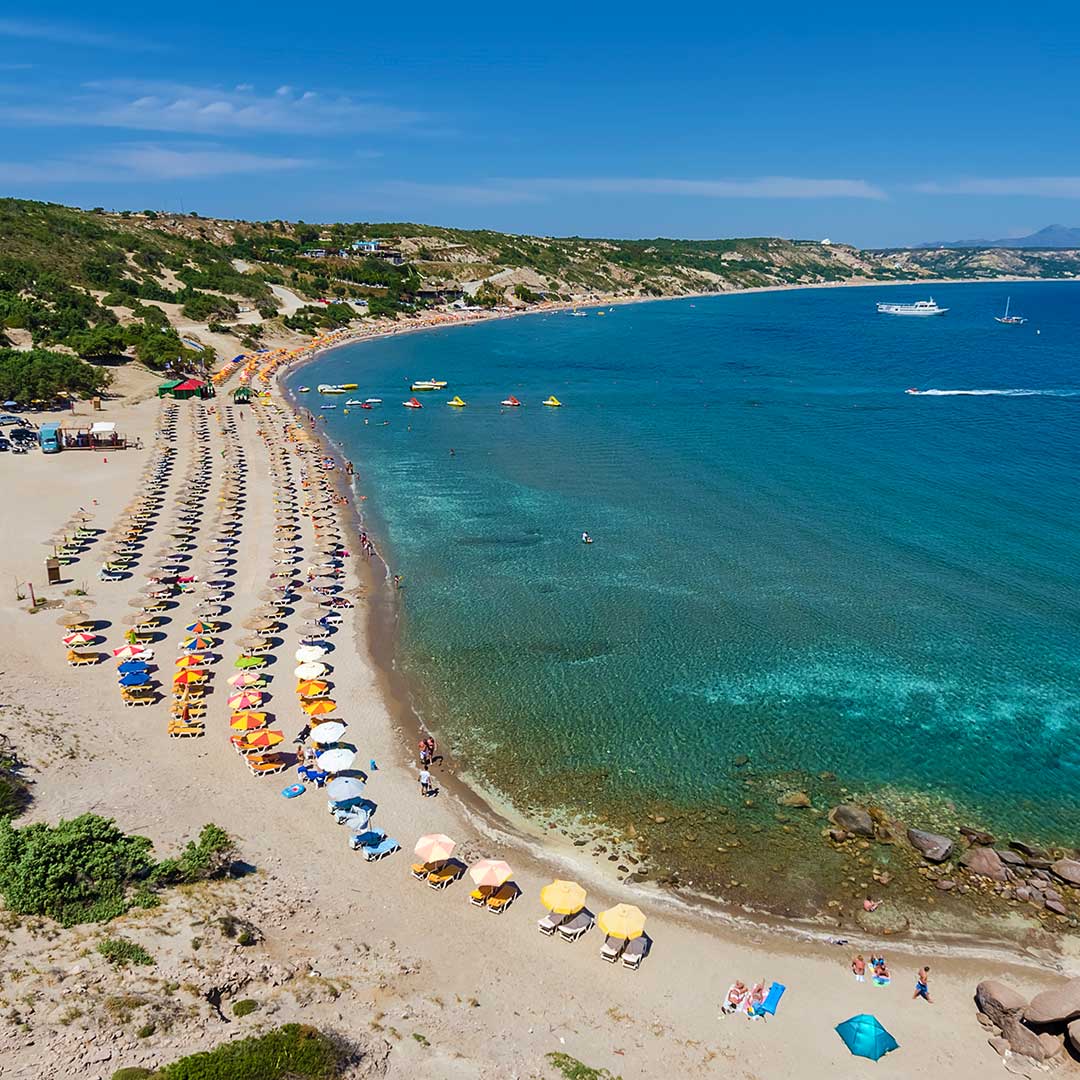 Blick auf Paradise Beach mit Sonnenliegen und Schirmen auf Kos