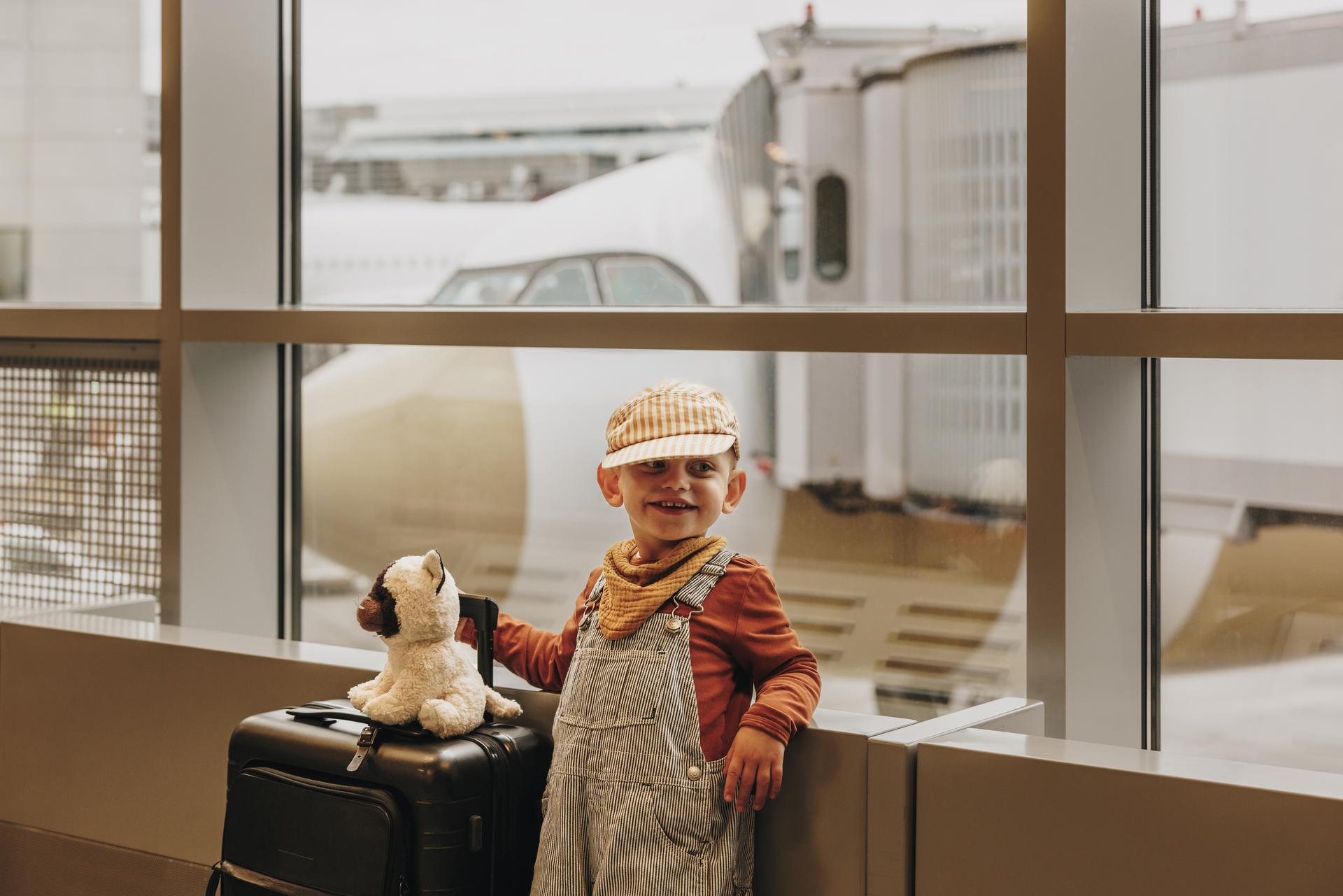 Kleines Kind mit Gepäck am Flughafengate