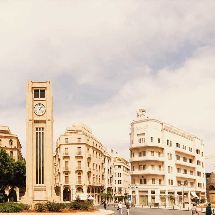 Der Uhrturm auf dem Sternplatz im Zentrum Beiruts, umsäumt von Pflanzen, Bäumen und einem Kreisel für Fußgänger und Fahrzeuge.