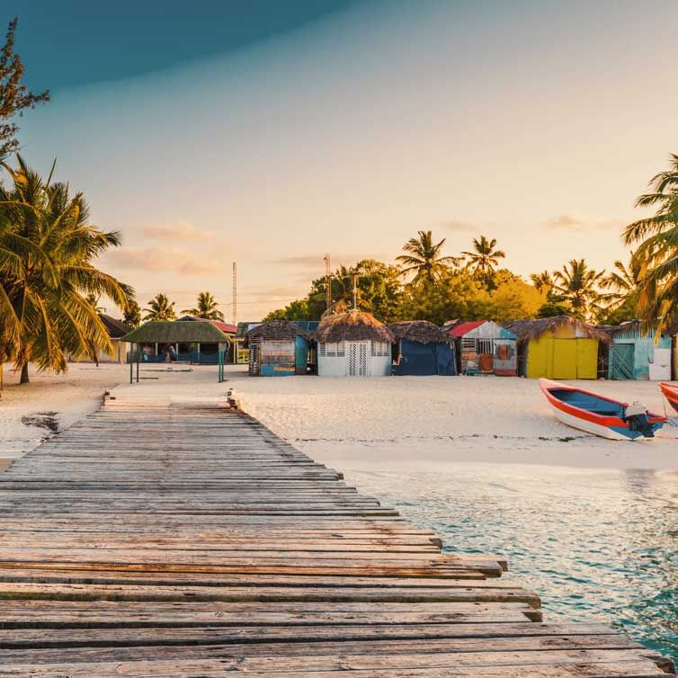 Ein Strand in Punta Cana mit weißem Sand und bunten Hütten