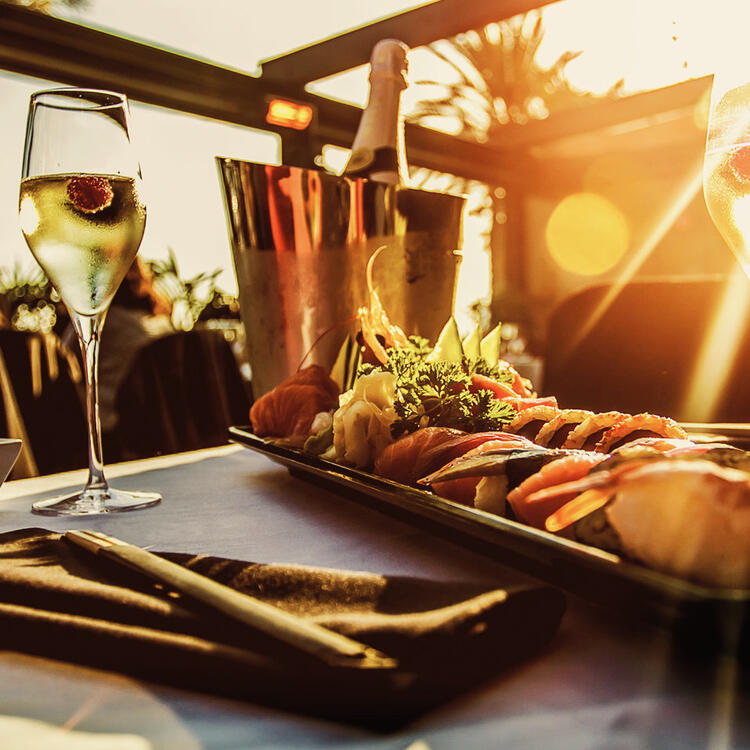 Restaurante Grill Sal y Brasa Gran Canaria | Condor Frische Meeresfrüchte-Platte und Champagner serviert am Tisch im Restaurant, schönen Sonnenuntergang