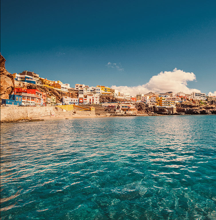 Blick auf ein typisches Dorf auf der Insel Gran Canaria vom Meer aus.