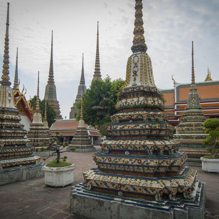 Blick auf die farbenprächtigen Chedis im Wat Pho, einem der ältesten Tempel in Bangkok, mit reich verzierten Mosaiken