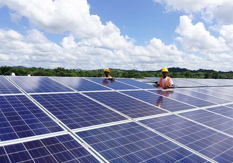 Solarkraftwerke Zwei Männer stehen inmitten von Solarpaneelen auf einer freien Fläche