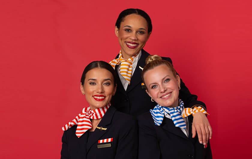 Young Talents | Cabin Crew Fünf Mitglieder der Cabin Crew posieren vor einer gelben Wand.