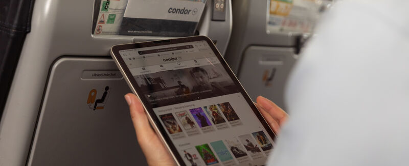 Ein Paar hat ein Tablet auf dem Klapptisch an Bord des Flugzeugs aufgestellt Ein Paar hat ein Tablet auf dem Klapptisch an Bord des Flugzeugs aufgestellt