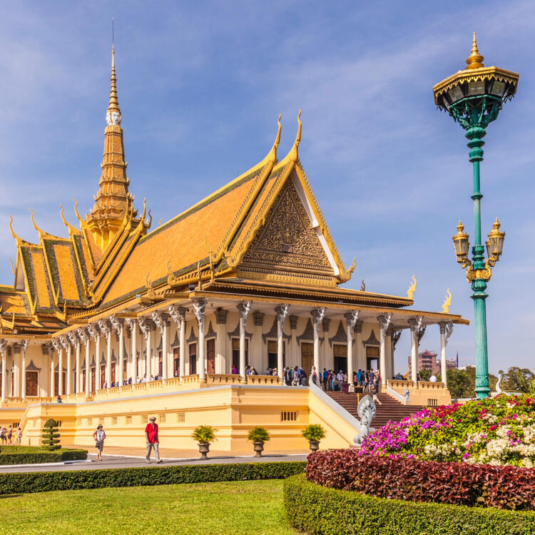 Prächtiger Königspalast in Phnom Penh mit vergoldeten Dächern, filigranen Ornamenten und gepflegten Gärten bei Sonnenschein.
