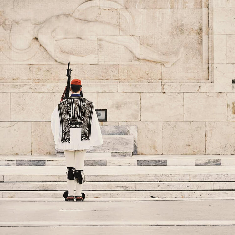 Ehrenwache der Evzones vor dem Grabmal des Unbekannten Soldaten am Parlamentsgebäude auf dem Syntagma-Platz in Athen, Griechenland.
