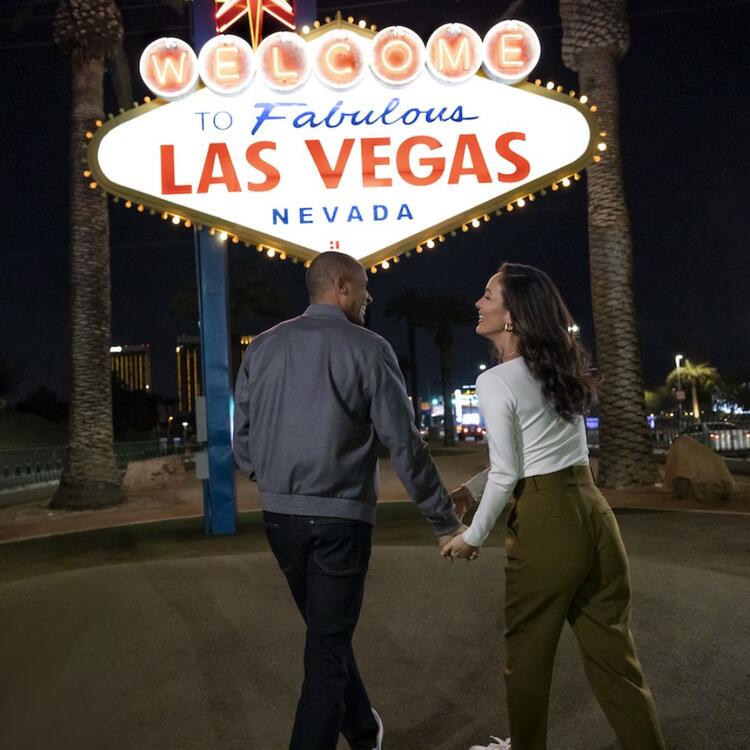 Paar bei Nacht vor dem Schild "Welcome to Fabulous Las Vegas Nevada"