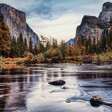 Bils des Yosemite Nationalparks in Kalifornien, das den Merced River, den El Capitan und die beeindruckenden Berge zeigt.
