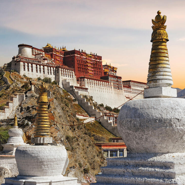 Potala palast im Sonnenuntergang mit vergoldeten Türmen auf den Säulen der Mauer