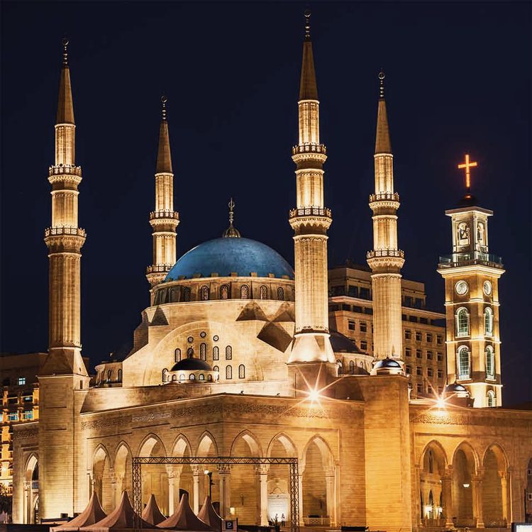 Die berühmte Mohammed-al-Amin-Moschee in Beirut, hell erleuchtet vor blauem Nachthimmel.