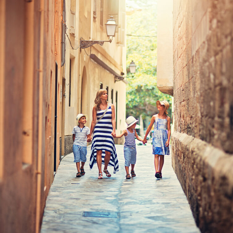 Eine Familie schlendert durch Gassen auf der Insel Mallorca