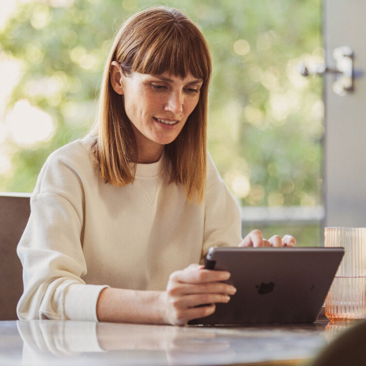 Frau mit Tablet am Tisch