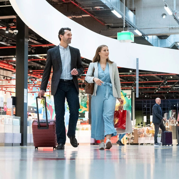 Mann und Frau beim laufen mit Gepäck am Berliner Flughafen