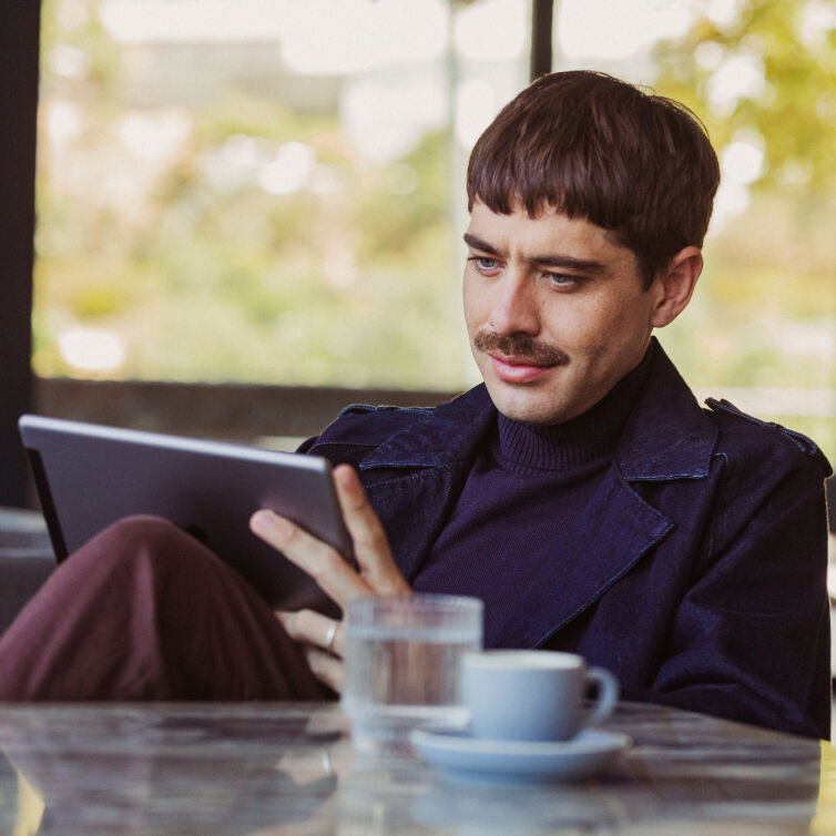 Mann mit Tablet am Tisch