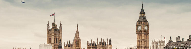 Blick auf den Palace of Westminster und den Big Ben in London unter bewölktem Himmel.