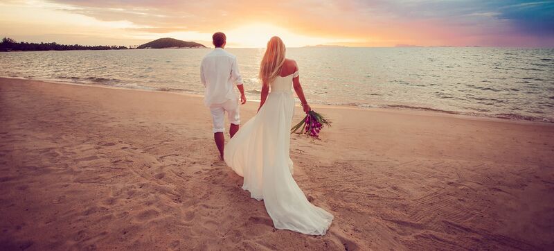 Heiraten am Meer Brautpaar läuft über den Strand