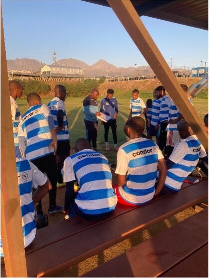 Young Bafana Ein Einblick in ein Fußballtraining, bei dem die Spieler blau-weiß-gestreifte Condor Trikots tragen