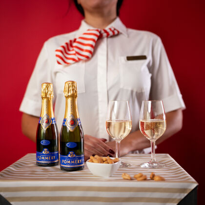 Champagner Aktion zwei Flaschen Pommery Brut Royal auf einem Tisch mit zwei Gläsern und Nüssen als Snack