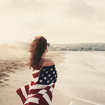 Frau mit einer US-Flagge am Strand von Los Angeles (LAX), Condor Ziel