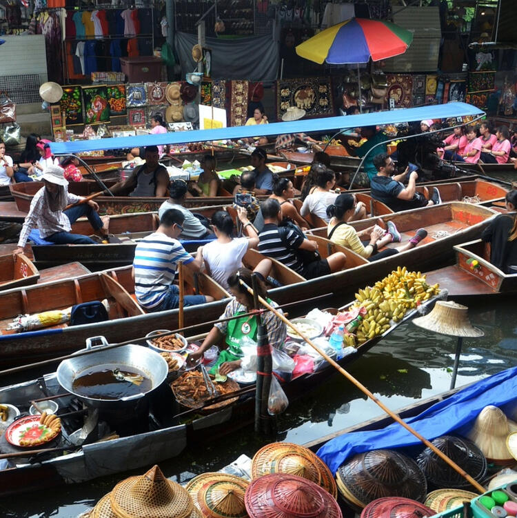 Schwimmender Markt in Bangkok mit zahlreichen Booten, die lokale Produkte und frisches Essen verkaufen