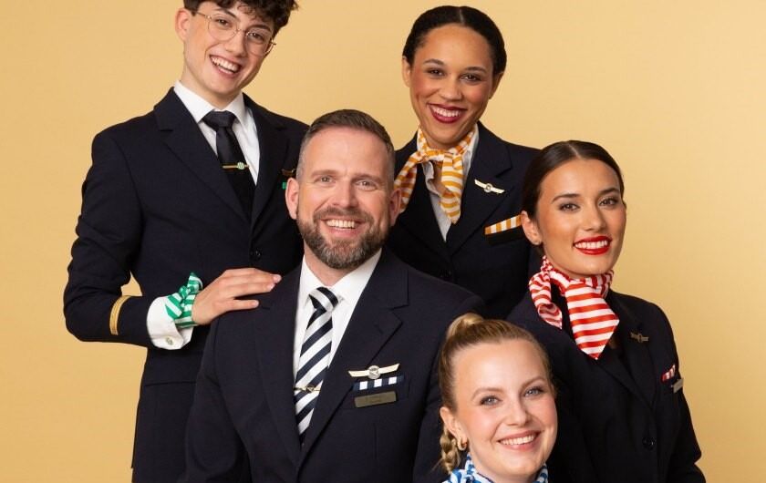 Young Talents | Cabin Crew Fünf Mitglieder der Cabin Crew posieren vor einer gelben Wand.
