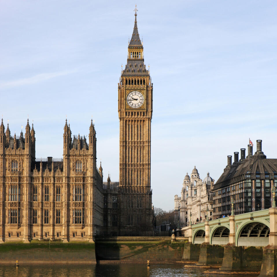 Big Ben in London in sunlight with Westminster Bridge in the foreground.