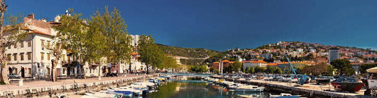 Panoramaansicht des Hafens von Rijeka in Kroatien, mit einer Reihe von geparkten Booten und Yachten entlang der Uferpromenade