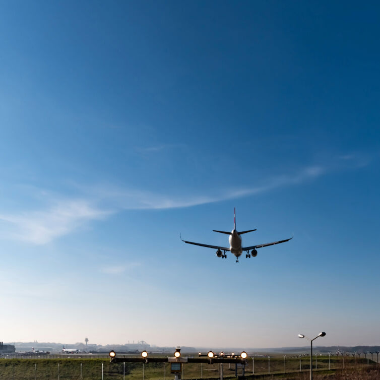 Flugzeug im Landeanflug unter blauem Himmel am Hamburger Flughafen
