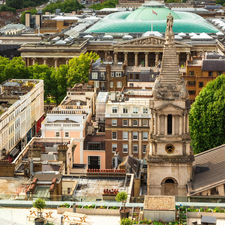 Luftaufnahme des Zentrums von London mit historischen Gebäuden und dem grünen Glasdach des British Museum im Hintergrund.