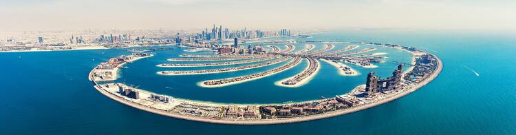 Luftaufnahme der Palmeninsel Jumeirah in Dubai, umrandet von Wasser.