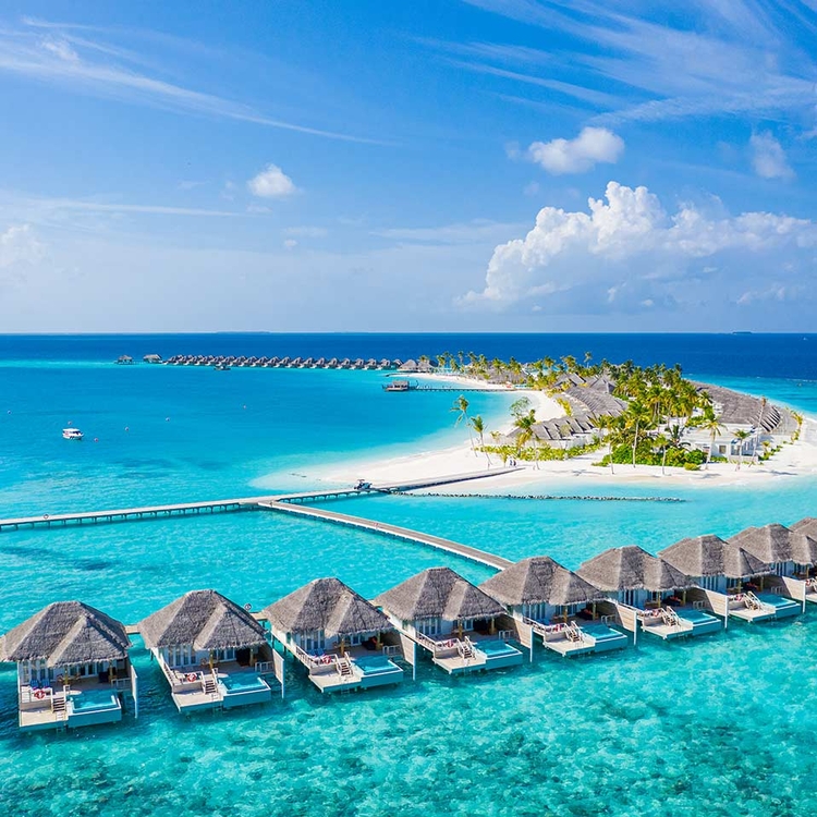 Überwasser-Bungalows Hotel. Türkisblaues Wasser und weißer Sandstrand auf den Malediven Inseln