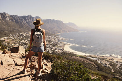 Eine Wanderin schaut hinab auf Kapstadt und das Meer